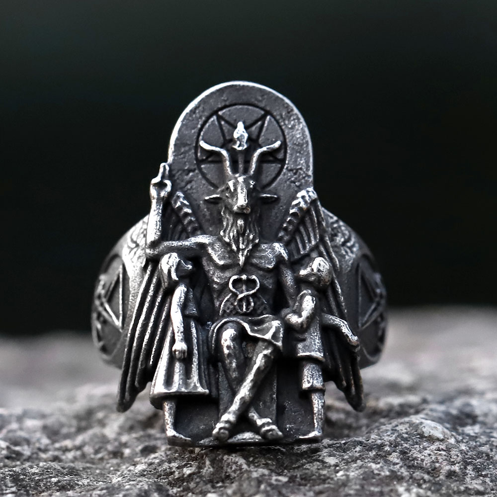 Detail of the Baphomet ring's top, focusing on the pentagram and goat head, with blurred green background.