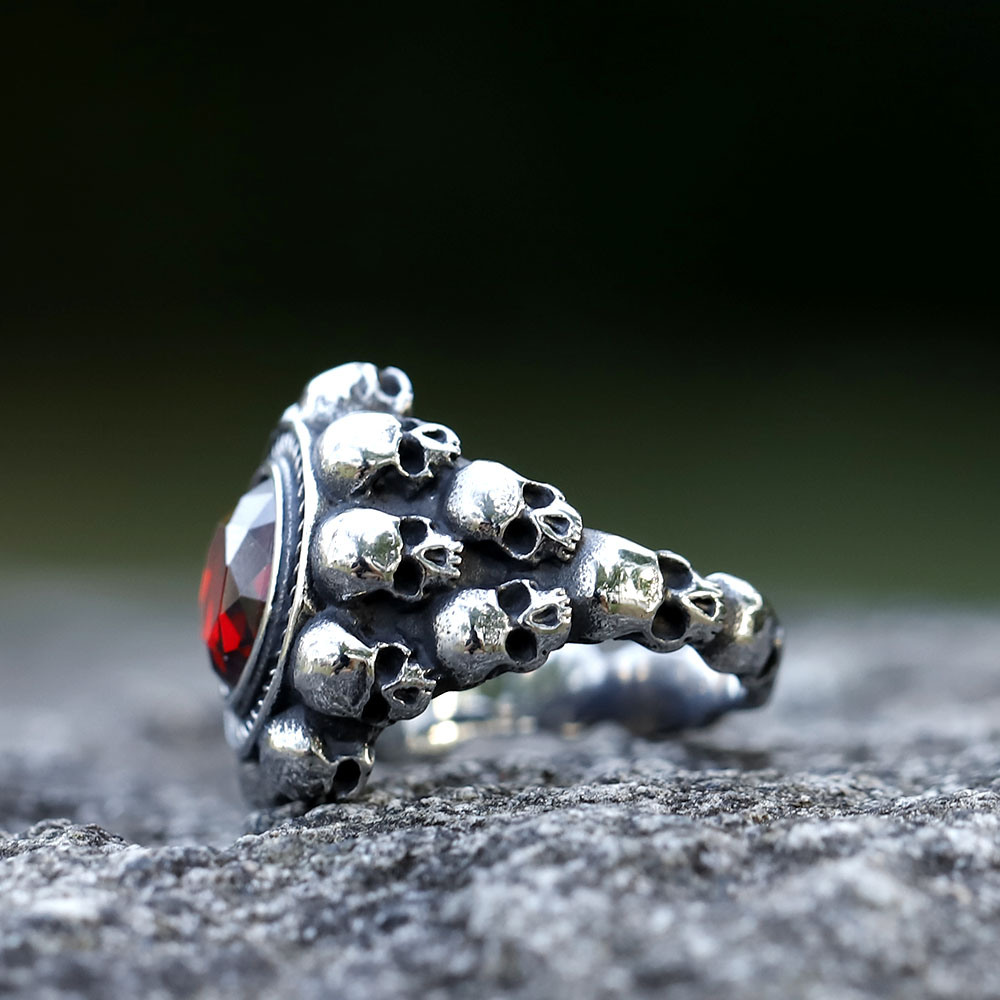 Side view of the stainless steel skull ring, showing the textured band adorned with multiple small skulls.