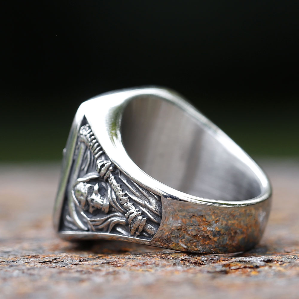 Close-up of the square ring face, showcasing the death sickle skull design and textured edges on a rustic surface.