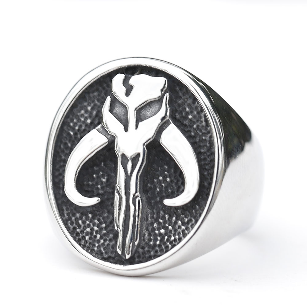 Side profile of the durable stainless steel Mandalorian ring, resting on an aged metal surface.