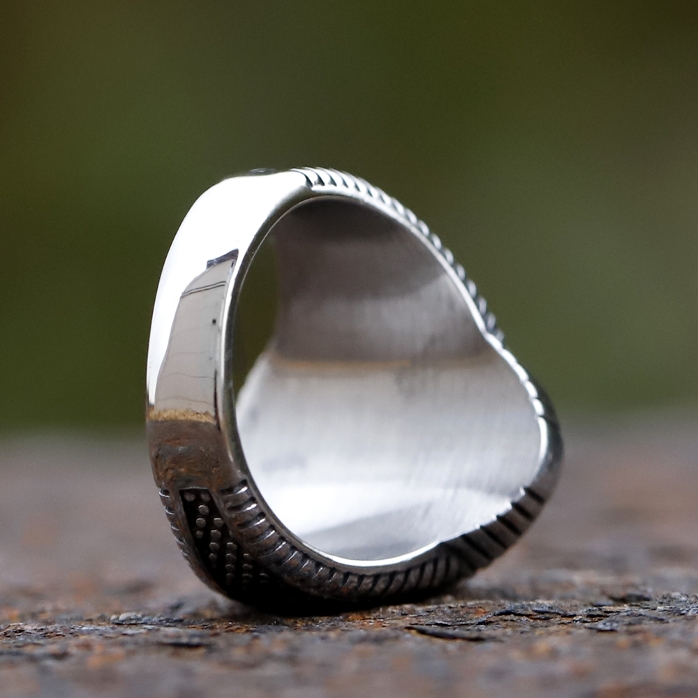 Top-down view highlighting the oval black zircon and ornate band