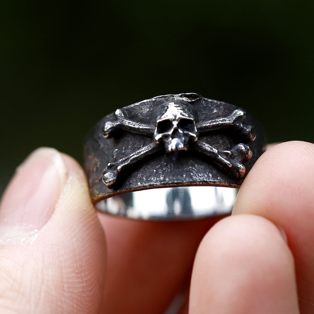 Detailed shot of the skull emblem on the vintage 316L stainless steel ring against a soft green background.