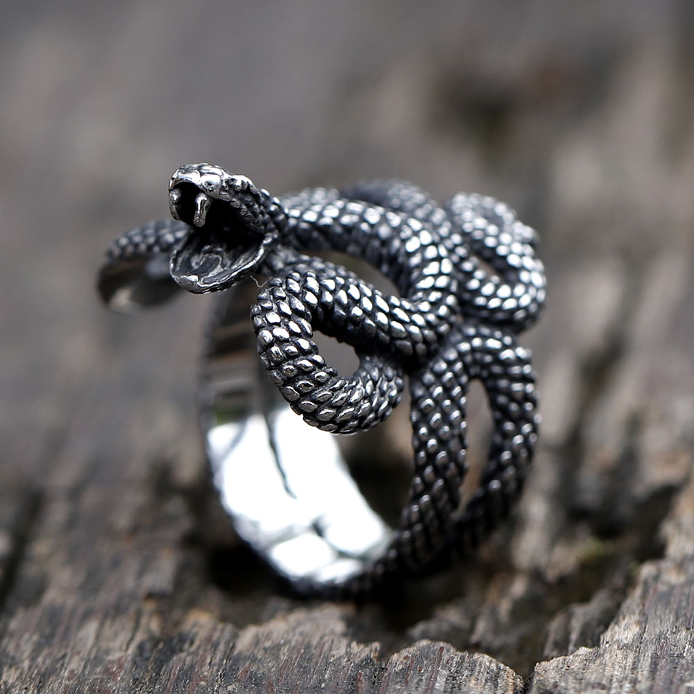 Close-up of the snake head on the 316L stainless steel ring, showing open mouth with fangs and textured scales.