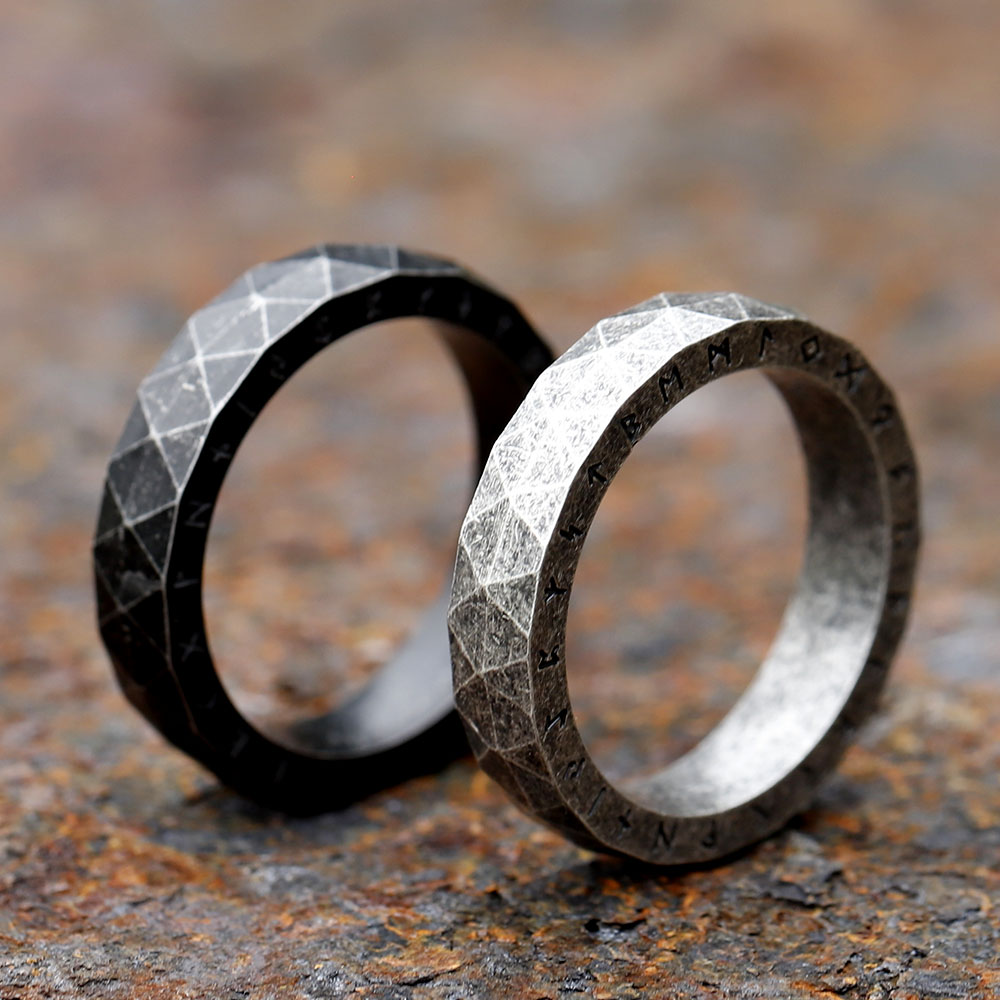 Focus on the dark, engraved Futhark runes adorning the outer edge of the stainless steel band.