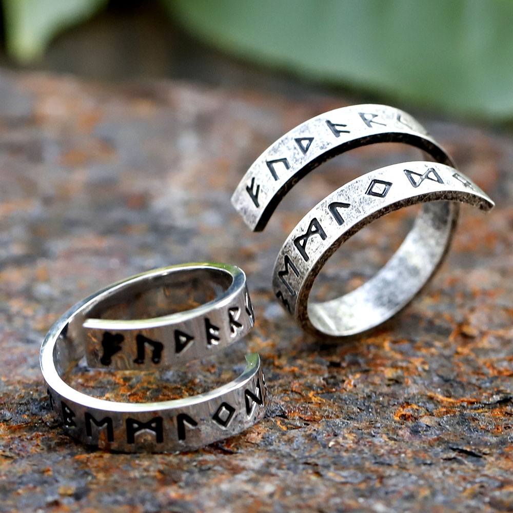 Angled view of the stainless steel rune ring, capturing the split band design and textured surface.