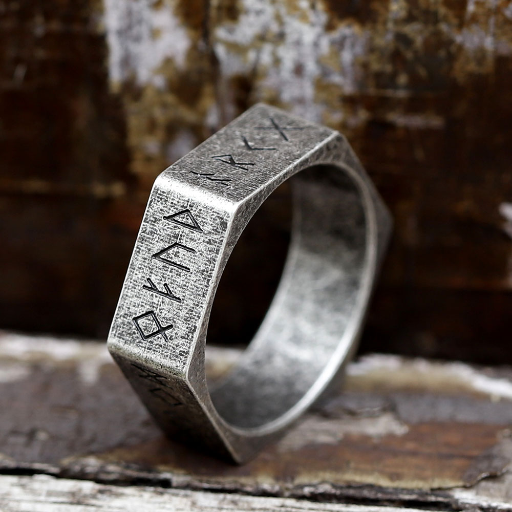 Antiqued 316L stainless steel hexagon ring featuring engraved Viking Nordic runes on a rustic background.