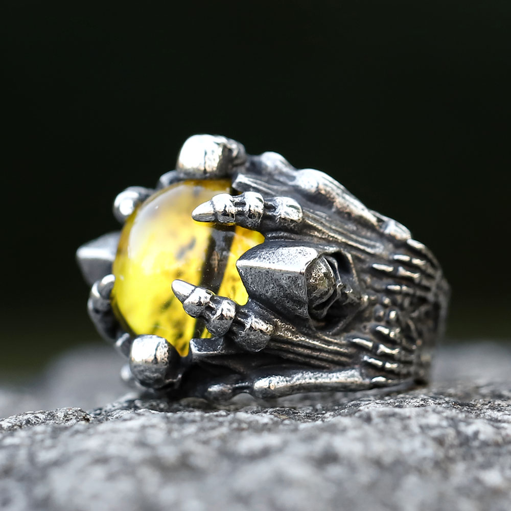 Stylish men's punk rock skull ring with vibrant red stone modeled on a finger for scale and fit.
