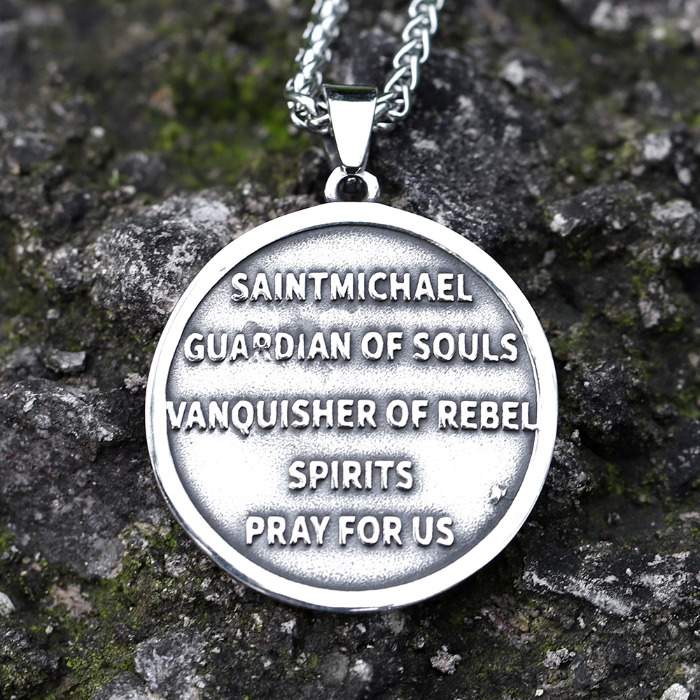 Close-up of the top left of the St. Michael pendant and chain on a textured background.