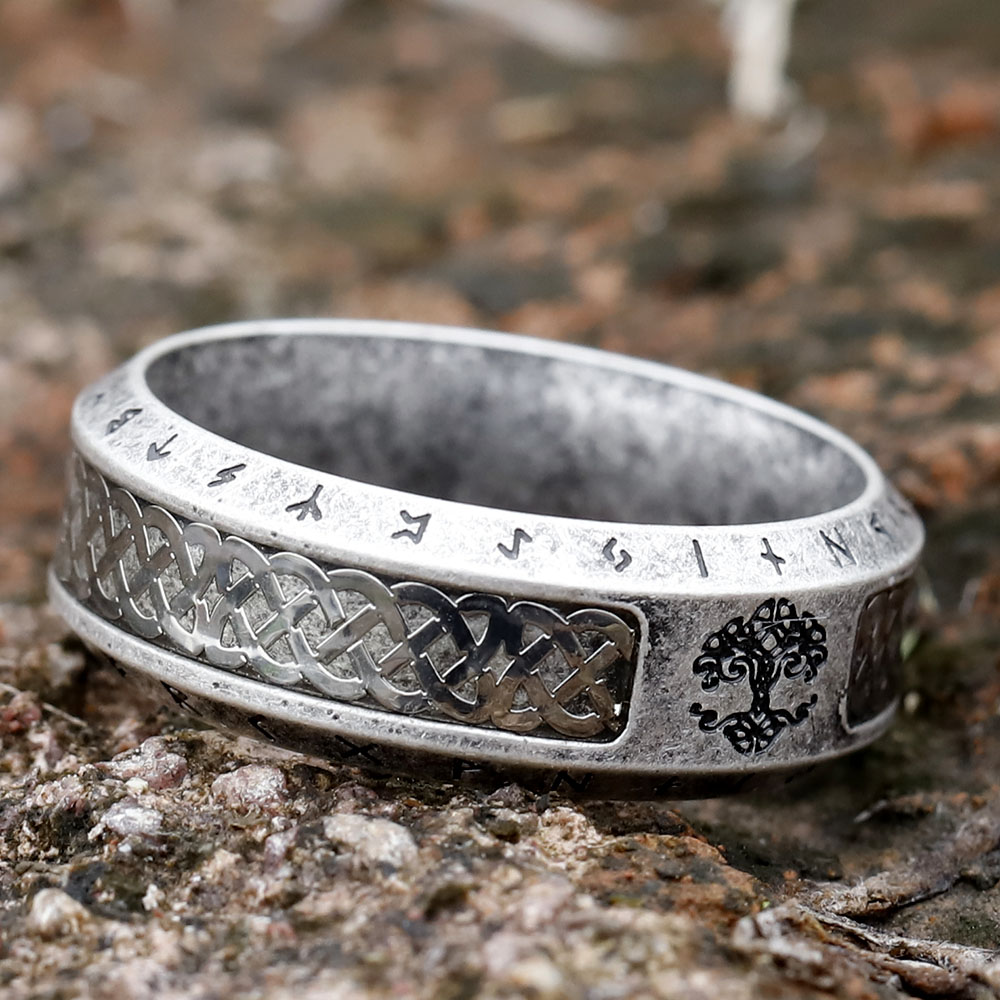 Angled shot focusing on the Tree of Life design and surrounding Futhark runes on the ring's surface.