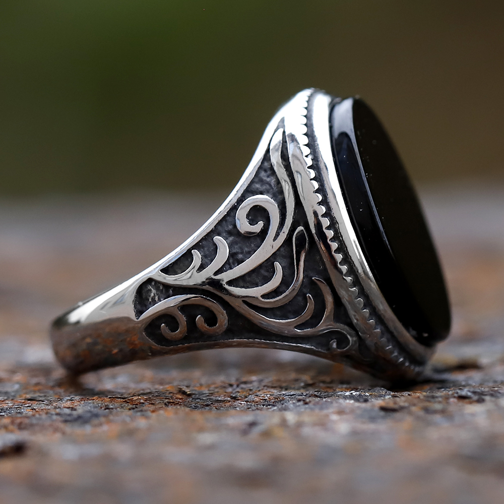 Top-down view of the black stone and silver bezel setting of the men's ring