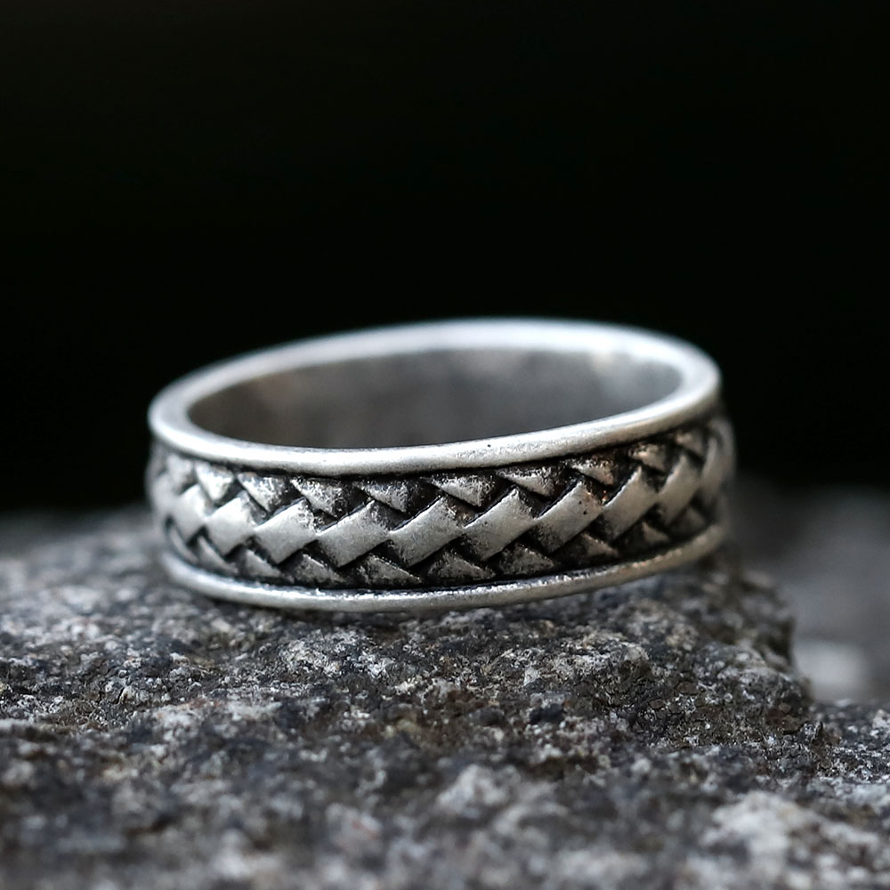 Detailed close-up of the intricate braided pattern on the side of a stainless steel men's ring